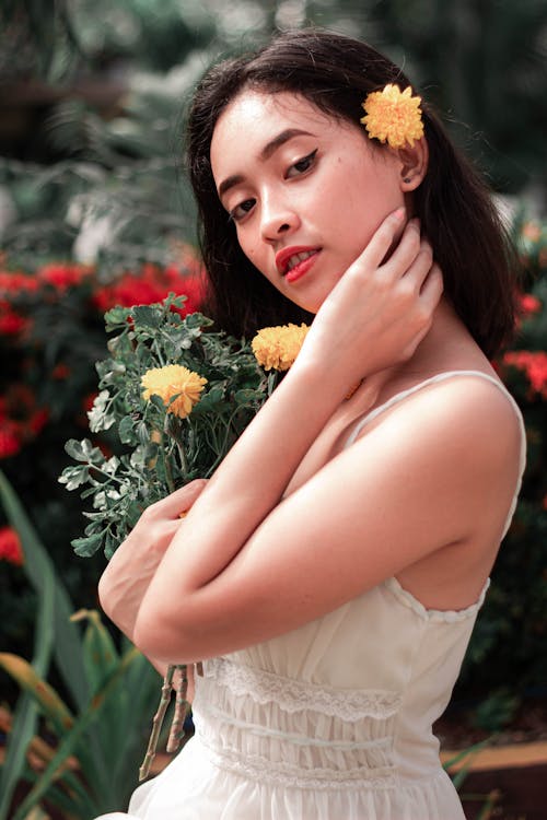 Foto d'estoc gratuïta de asiàtica, dona, flors grogues