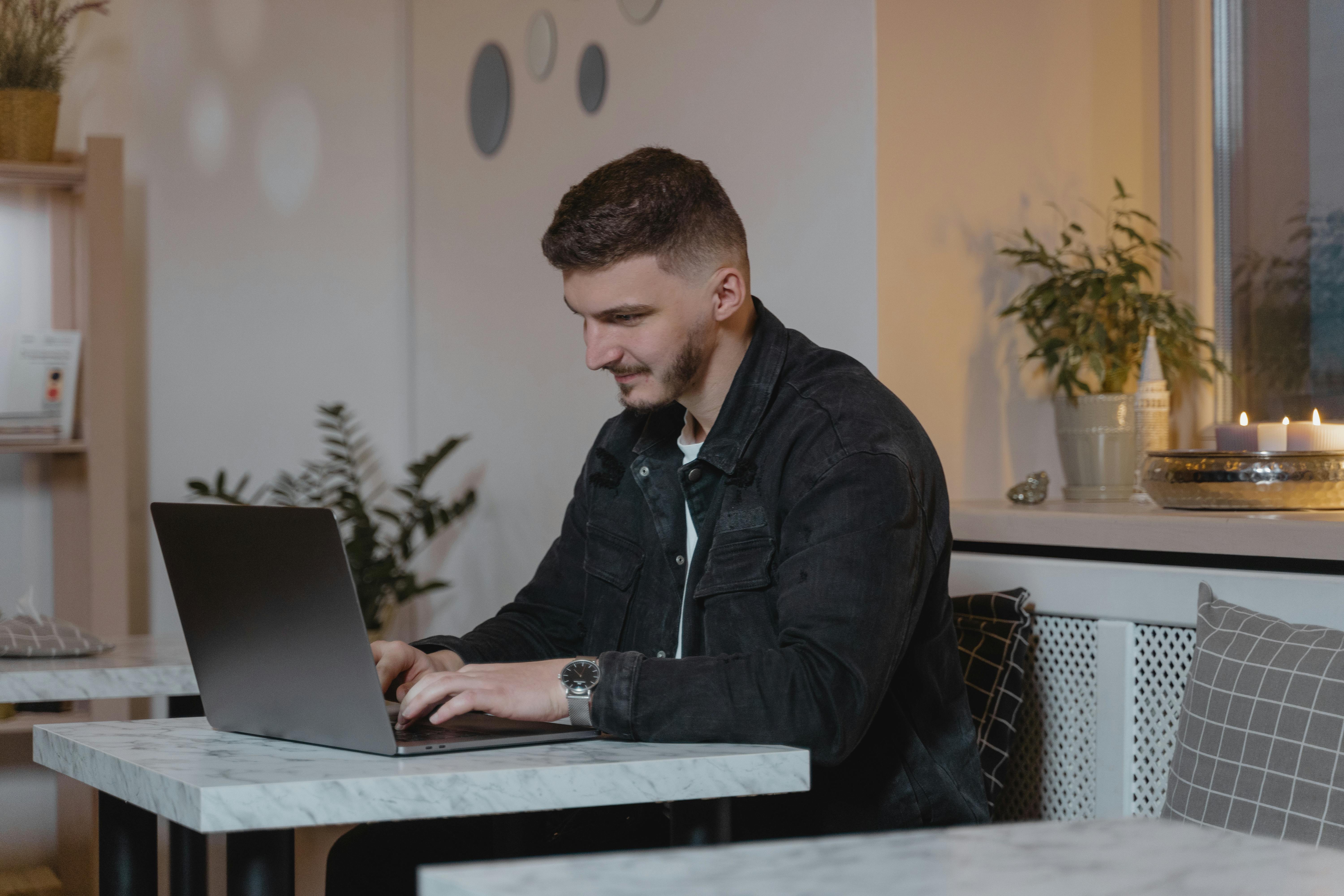A Man Using a Laptop Indoors · Free Stock Photo