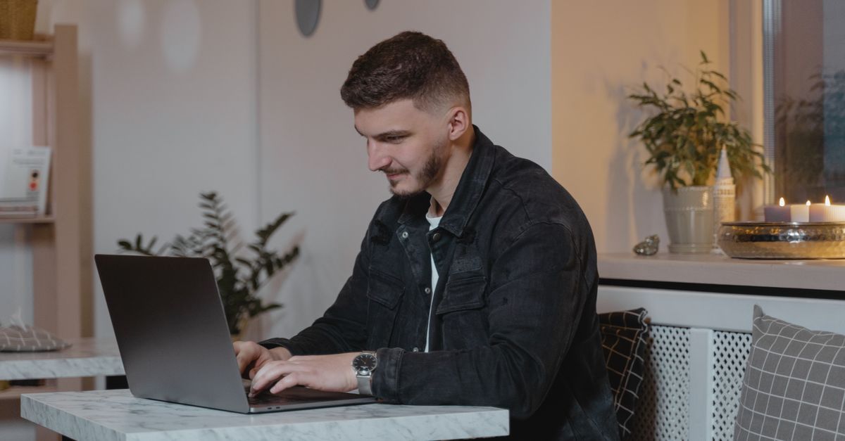 A Man Using a Laptop Indoors · Free Stock Photo