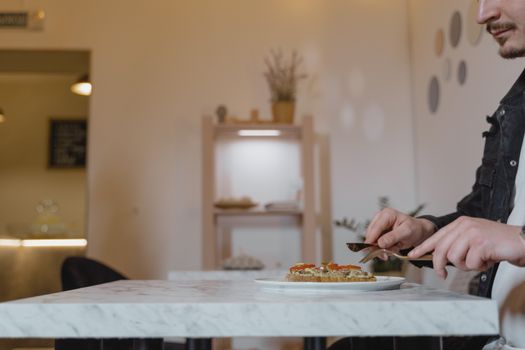 A man enjoying a healthy vegan meal in a cozy indoor cafe setting.