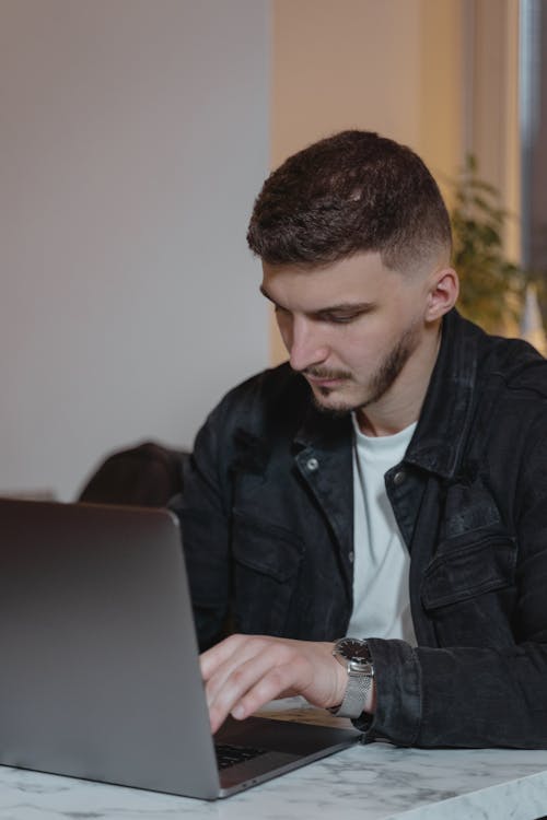 Man In Black Jacket Using Laptop