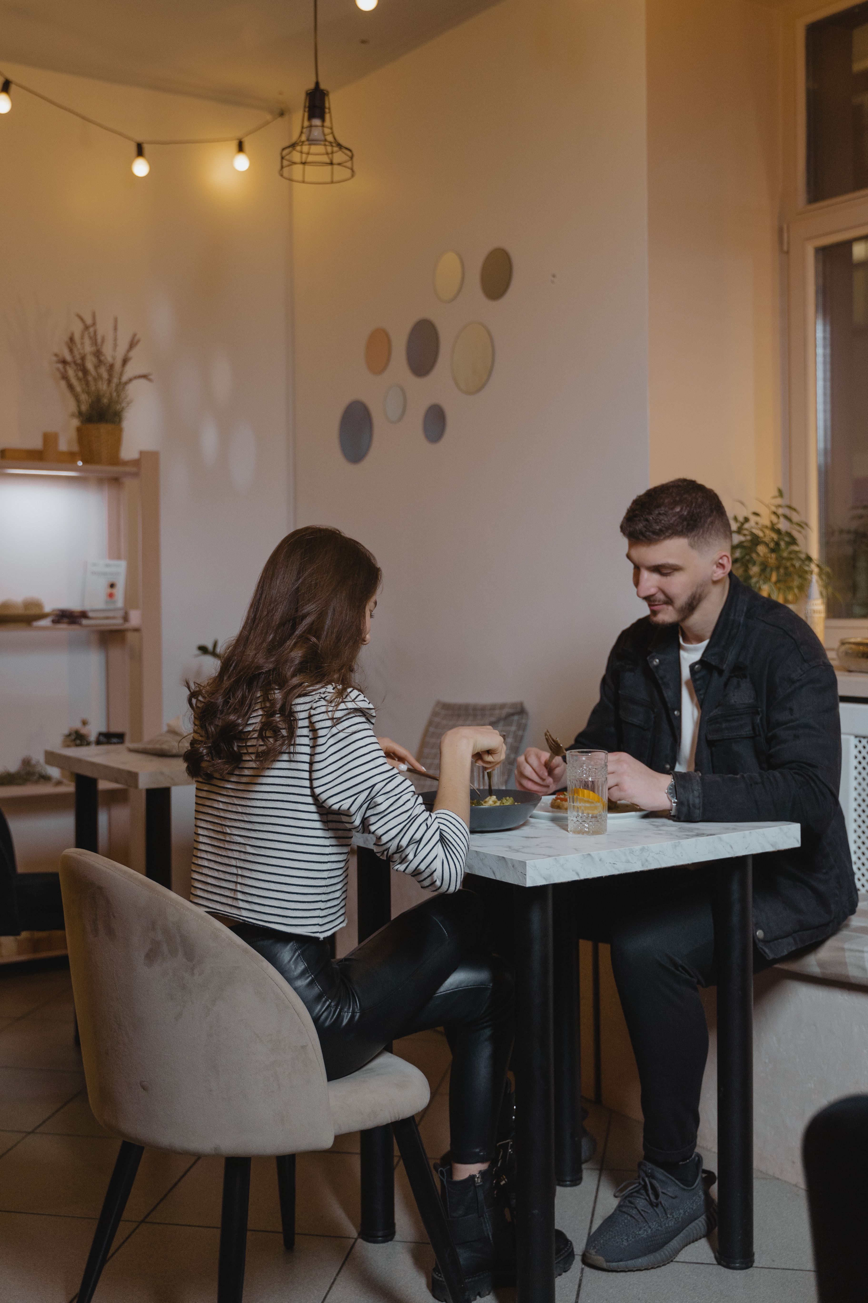 A man and woman enjoying a coffee date at a modern café, creating a cozy and romantic atmosphere.
