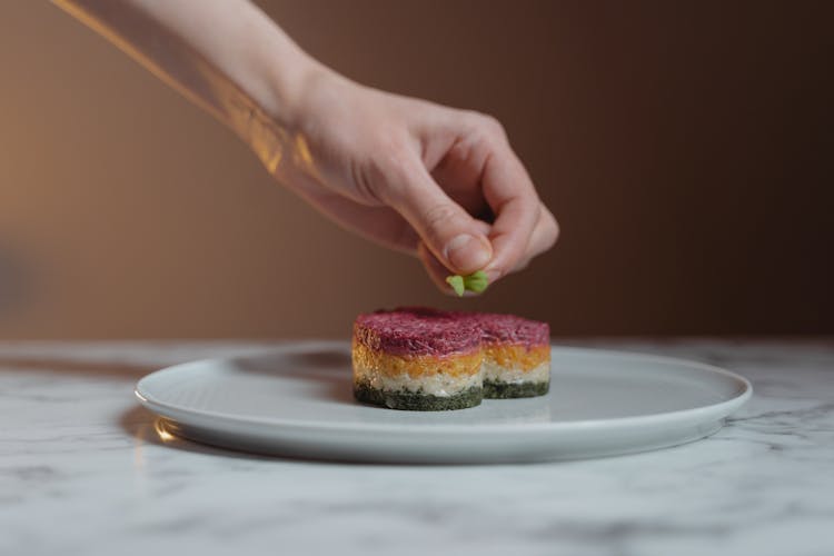 Hand Garnishing The Sticky Rice With Marjoram Leaf 