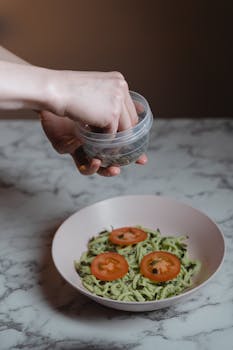A fresh vegan meal featuring zucchini noodles topped with tomatoes and seeds, perfect for a healthy lunch.