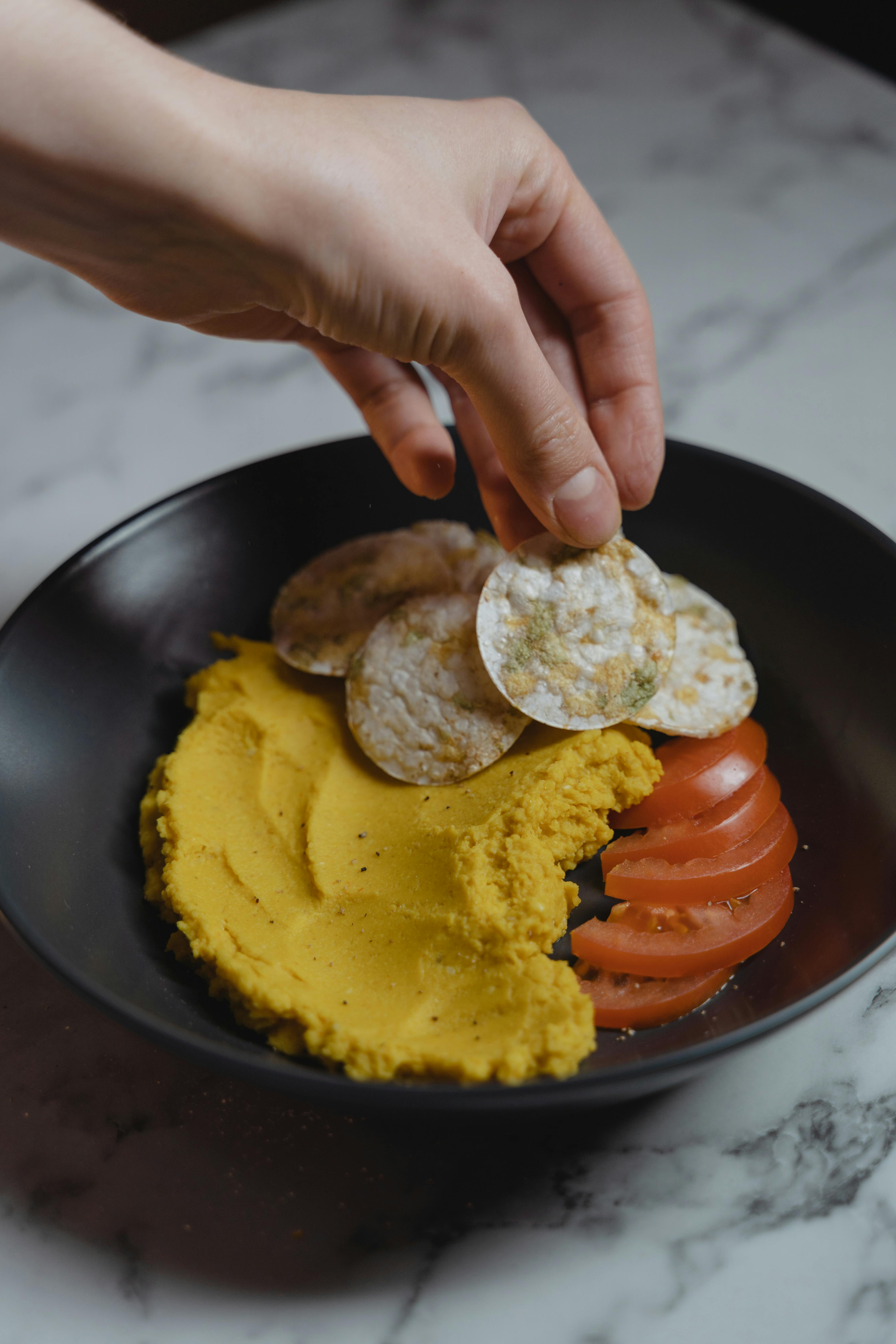 Person Holding Red Ceramic Plate With Food