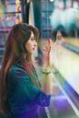 Calm ethnic woman standing near glass wall