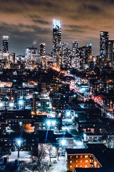 A stunning long exposure capture of Toronto's illuminated skyline at night, showcasing towering skyscrapers and city lights.