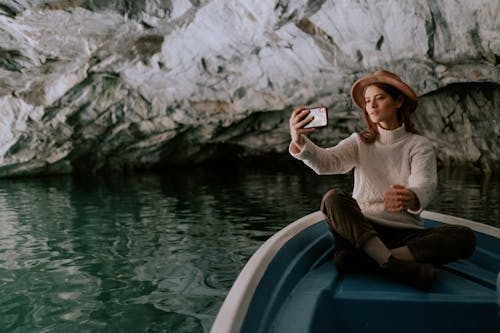 Free Woman Taking Selfie While Sitting on a Boat Stock Photo