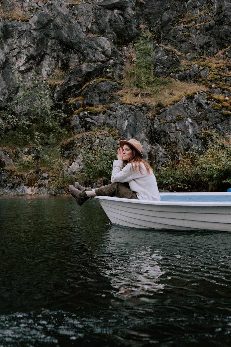 A Woman Sitting On The Boat While Sailing On The River