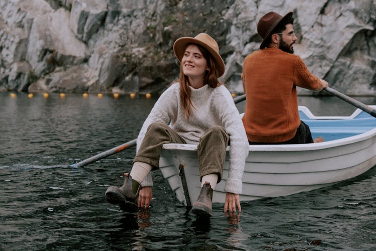 A Couple Sitting Back To Back While Riding A Boat