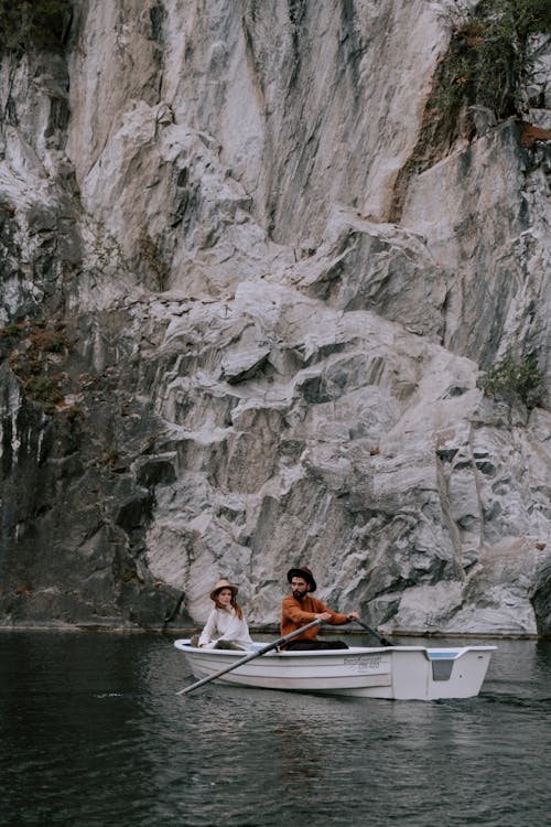A Couple Sitting on the Boat Near the Rock Formation