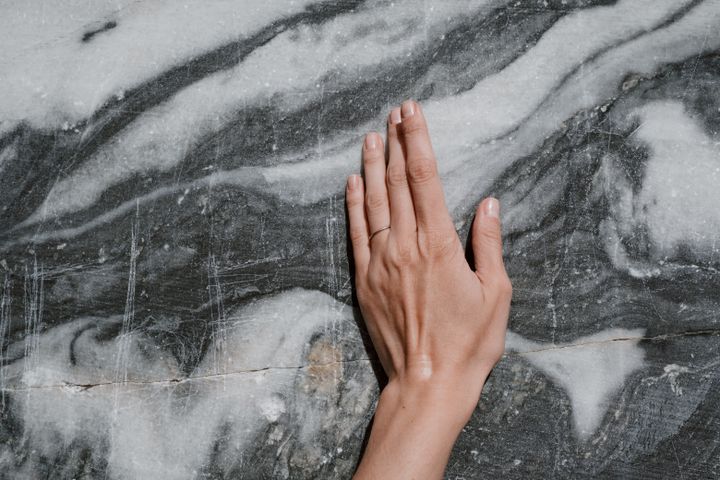 Hand resting on a polished marble surface