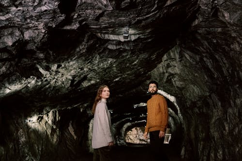 Man and Woman Looking Afar While Inside the Cave 
