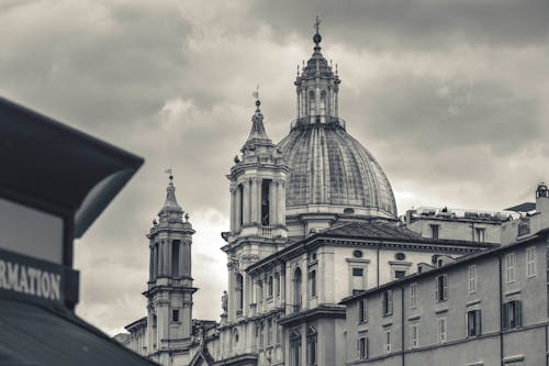 A Grayscale Photo of Concrete Church Under the Cloudy Sky