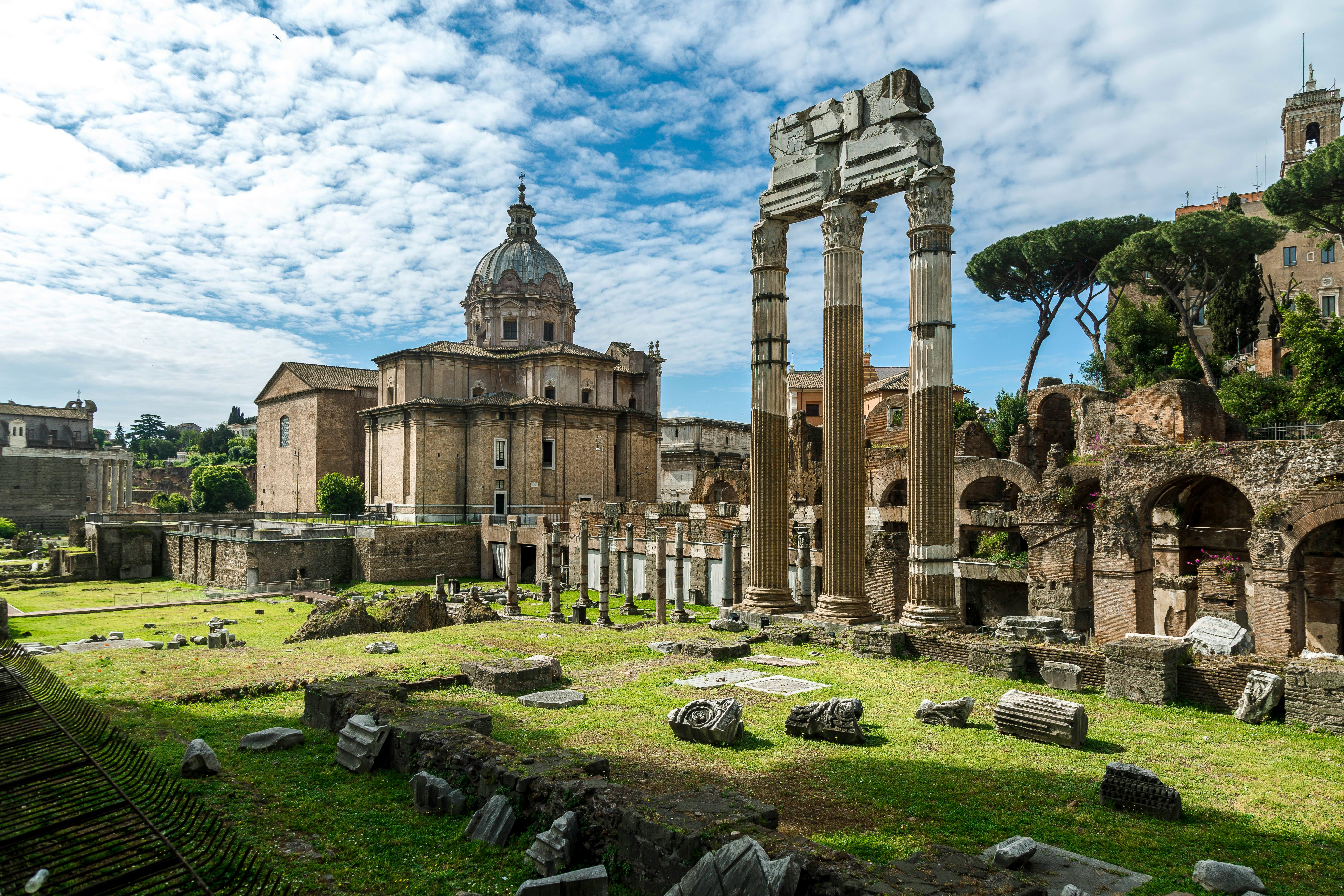 Explore the stunning ancient Roman ruins with iconic columns and cupola under a bright sky in Rome.