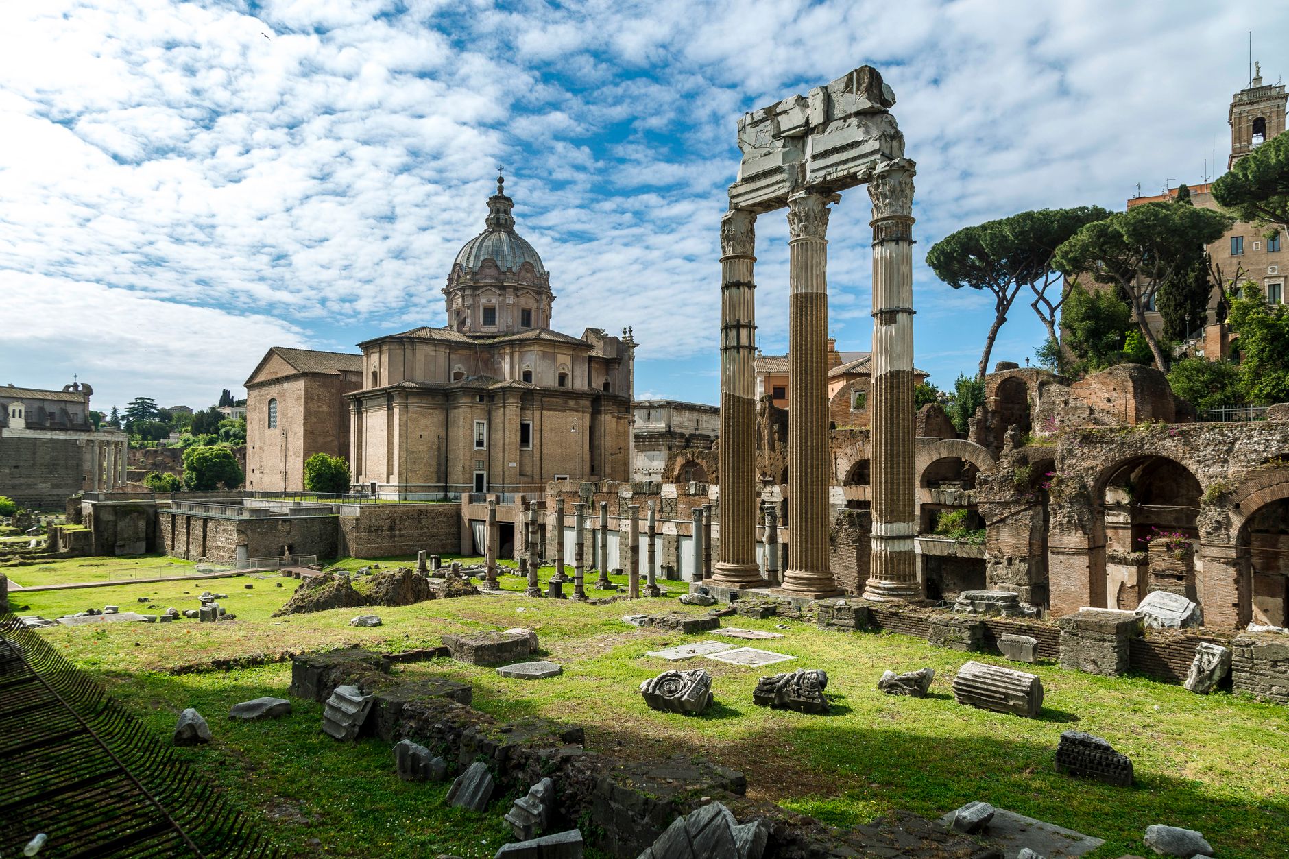 Explore the stunning ancient Roman ruins with iconic columns and cupola under a bright sky in Rome.