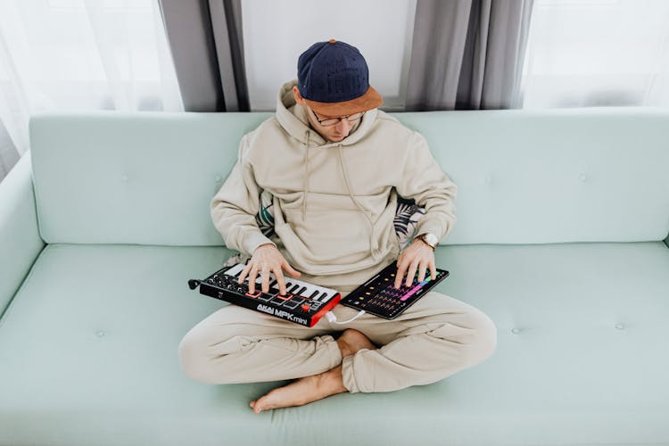 Man Creating Music On Pad And Keyboard