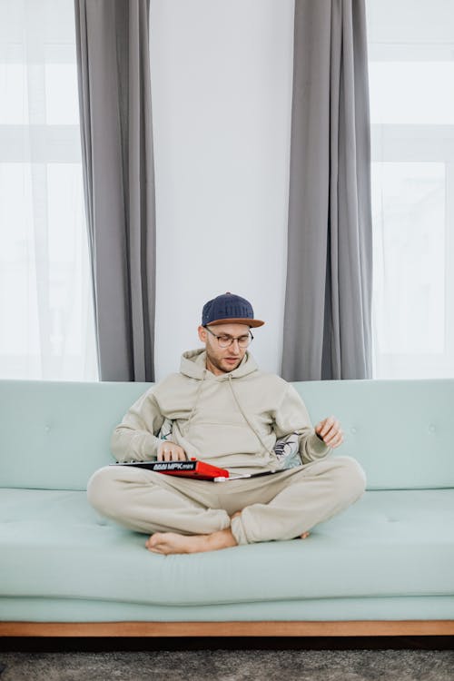 A Man in a Hoodie Using Electronic Devices