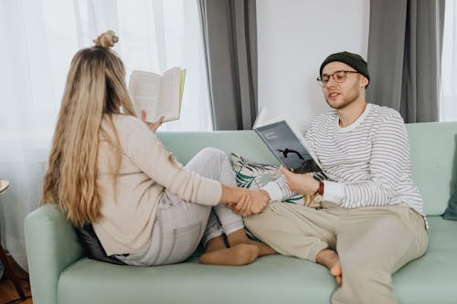 Free Couple Holding Hands While Reading Books Stock Photo