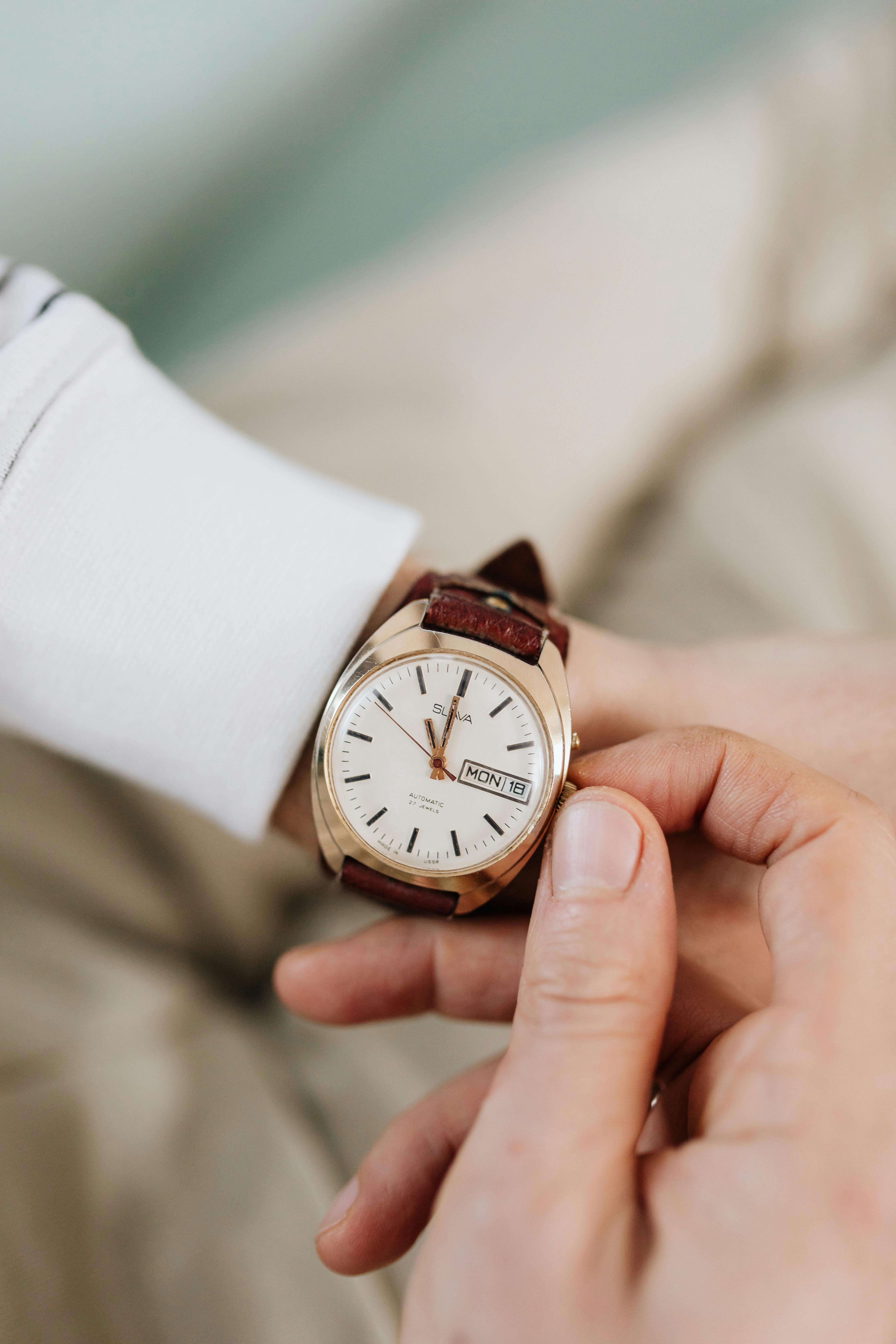 a person winding his wristwatch