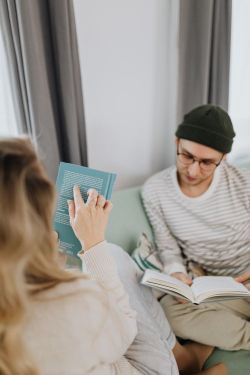 Free A couple enjoying a quiet moment reading books together at home, creating a cozy atmosphere. Stock Photo
