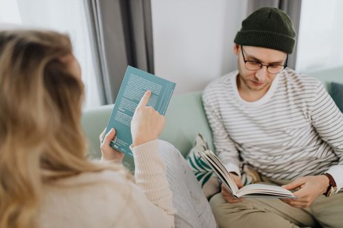 Free A couple enjoys a relaxing day reading on a comfortable sofa in a cozy home setting. Stock Photo