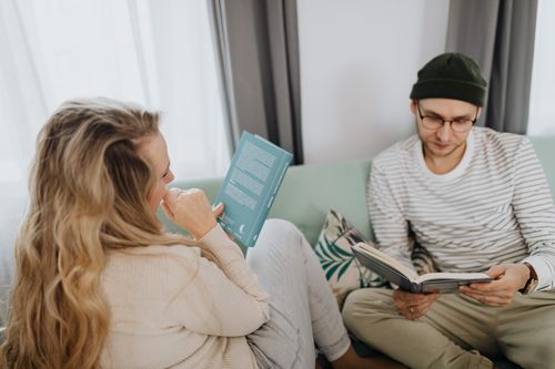 Free A couple enjoys reading books together in a comfortable living room setting. Stock Photo