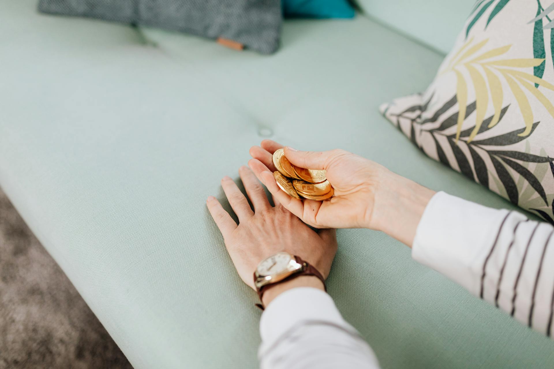 Hand Holding a Bunch of Gold Coins