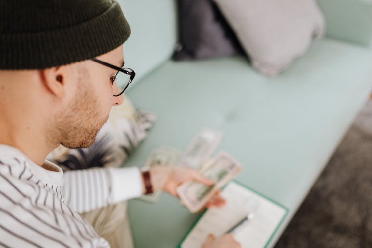 Man In Black Beanie Hat Holding Money 