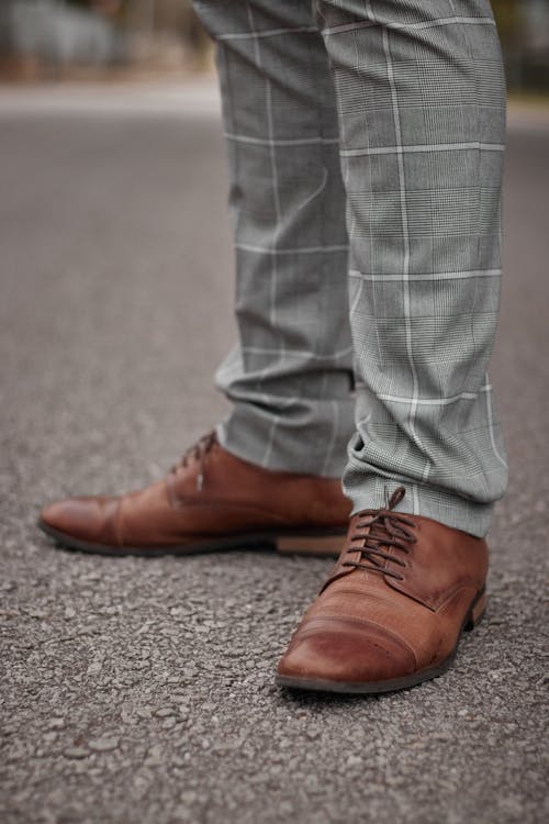 A Person in Gray Pants and Brown Leather Shoes