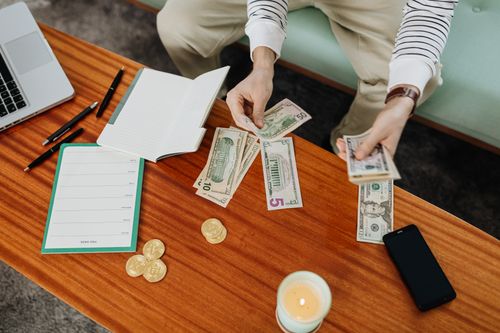 Free High angle view of hands handling money on a wooden table with digital currency coins. Stock Photo