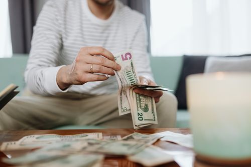 Free Close-up of hands counting dollar bills indoors, offering a personal finance theme. Stock Photo