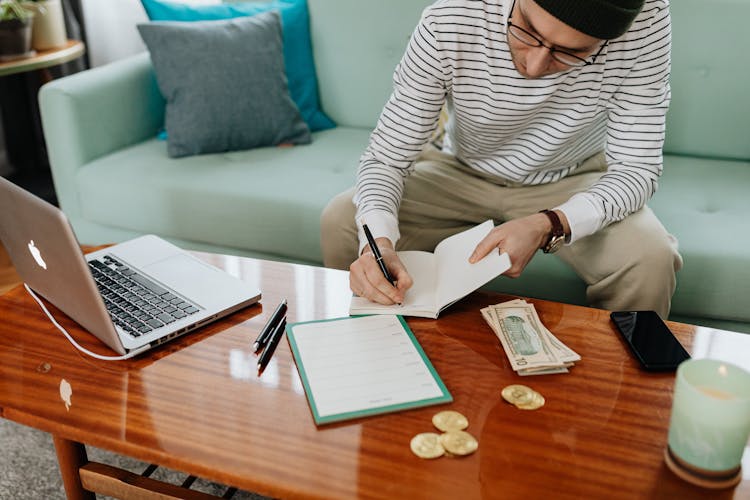 Man Writing On A Notebook