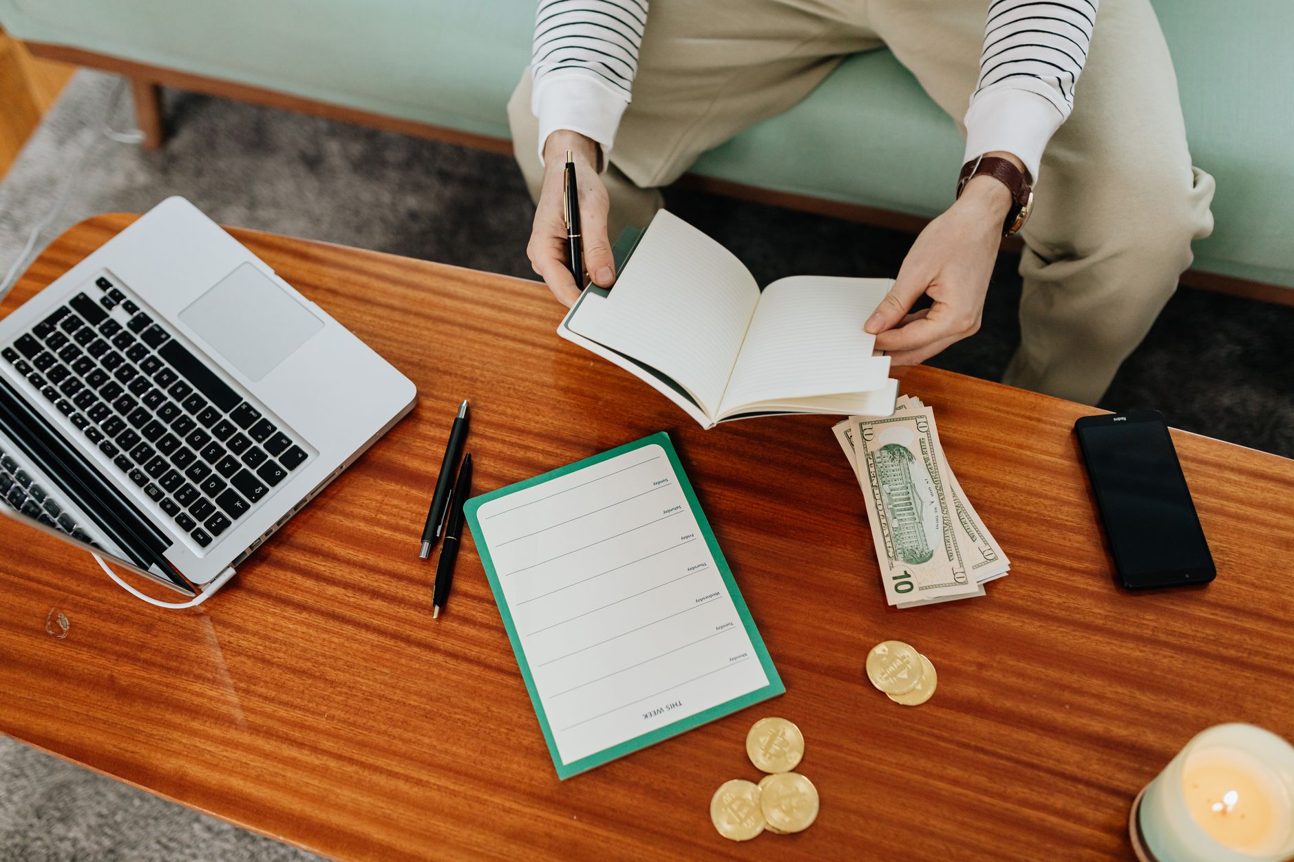 a budgeting notebook beside a phone showing deposit limits and a calm evening workspace