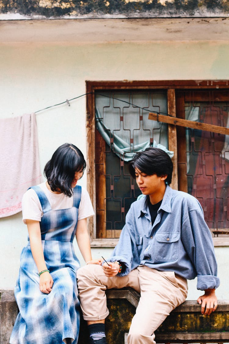 Happy Asian Couple Sitting On Border