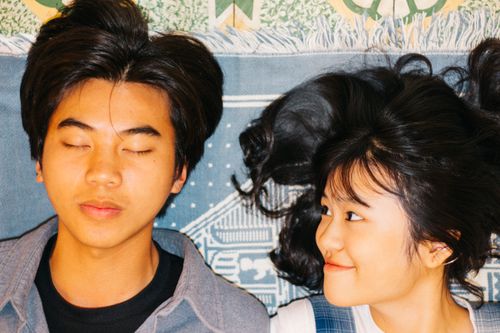 Free From above of cheerful Asian couple relaxing together on colorful plaid at home Stock Photo