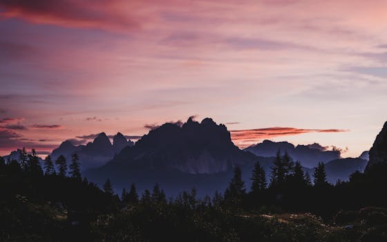 Majestic sunrise over the Dolomites in Veneto, Italy, casting silhouettes and colorful skies.