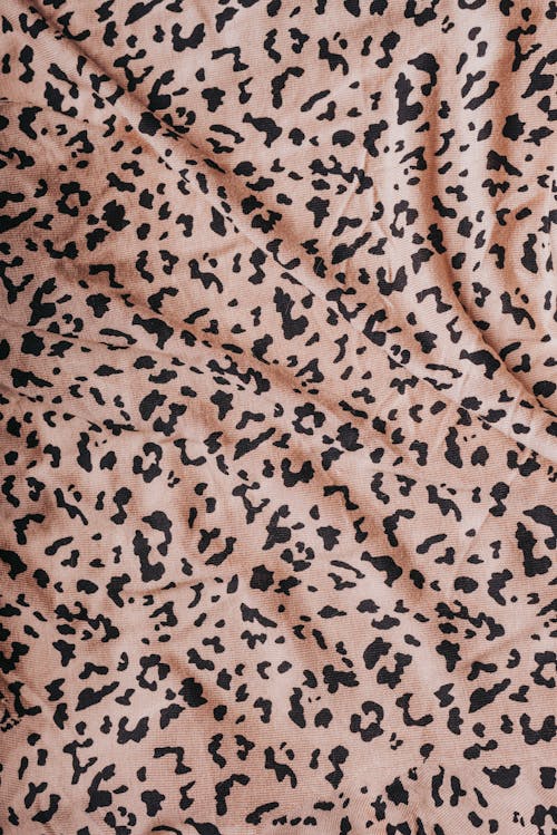 From above of smooth draped fabric with leopard animal print placed as abstract background