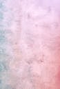 Pink and blue colored concrete weathered wall with uneven surface as abstract background