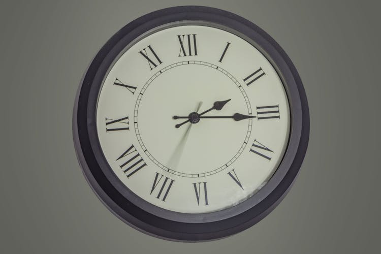 Round Clock Hanging On Gray Wall