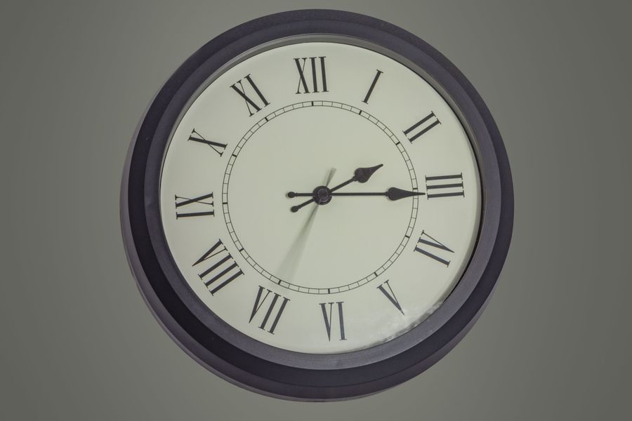 Round wall clock with Roman numerals