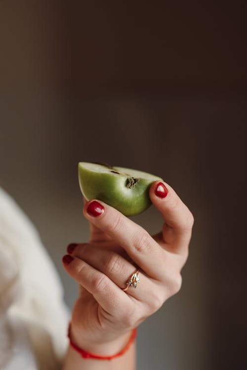 Female holding half of ripe apple