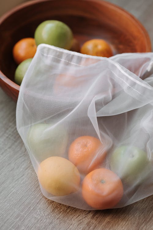 Lemon mandarins and apples in bag on table