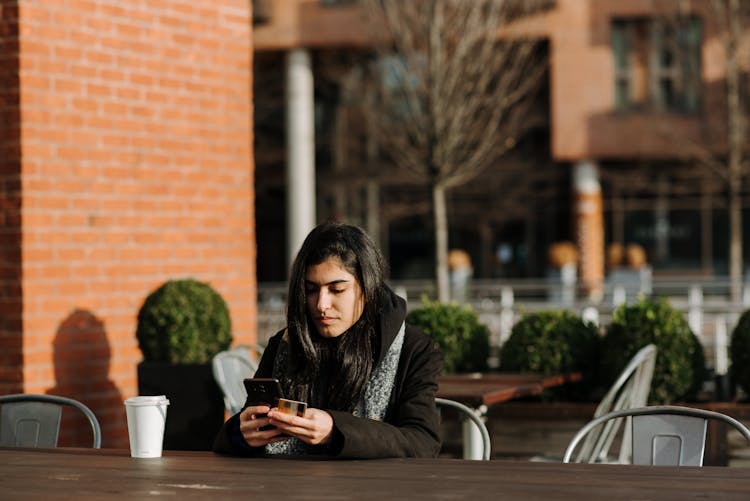 Ethnic Shopper With Smartphone And Debit Card In Street Cafe