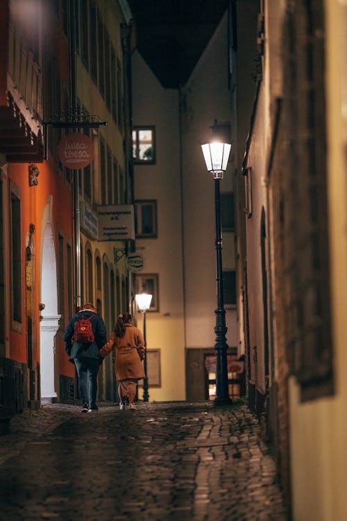 A Couple Walking In An Alley At Night