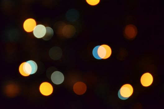 A vibrant display of colorful bokeh lights in various hues against a dark background.