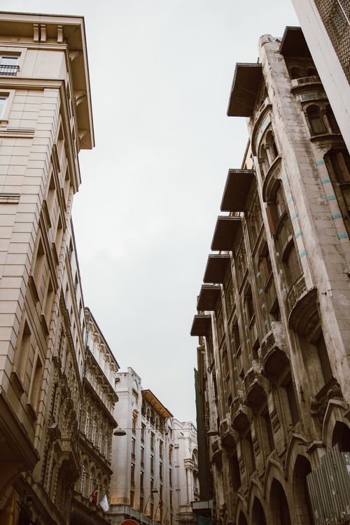 Free Low-angle view of historic urban buildings showcasing diverse architecture against a cloudy sky. Stock Photo