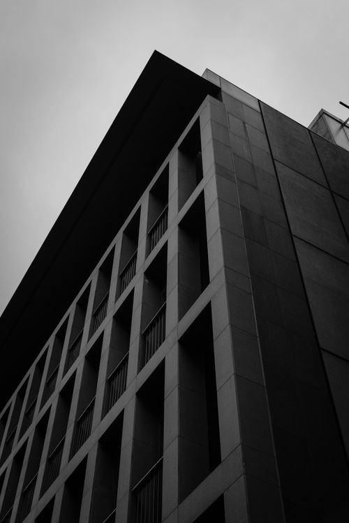 Free Low-angle view of a modern concrete building in monochrome, emphasizing geometric design. Stock Photo