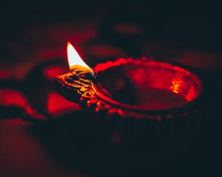 Close-up of a glowing diya lamp in dim lighting, symbolizing traditional Indian culture.