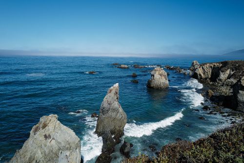 Free Breathtaking view of rugged cliffs and ocean waves along California's coastline. Stock Photo